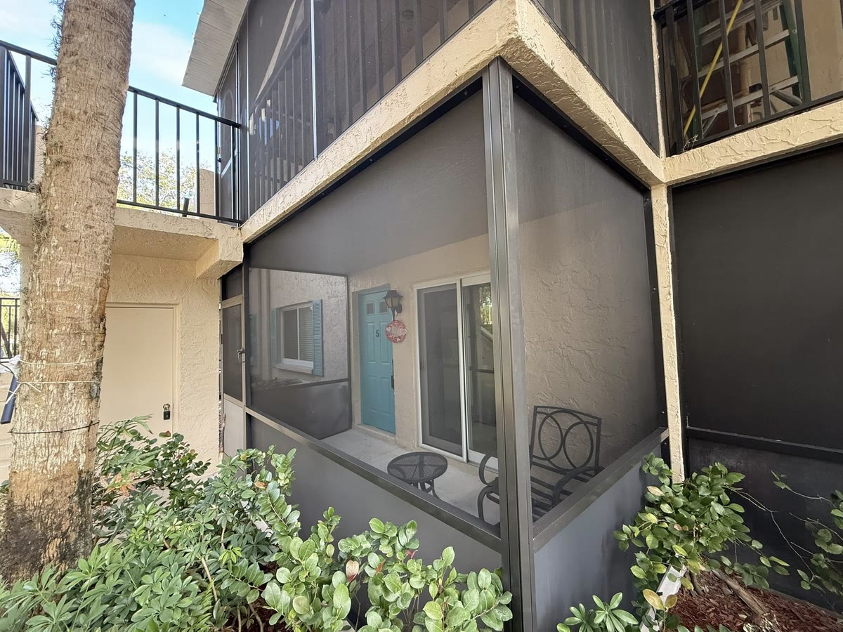 A screened courtyard entry between a garage and a two-storey house.