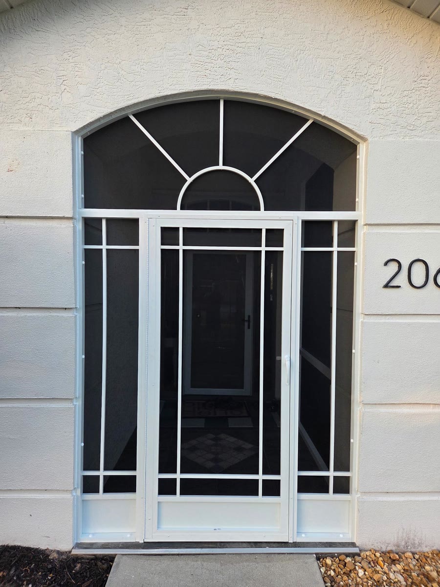 An arched white front entry enclosure with a screen door and a grid of white bars.