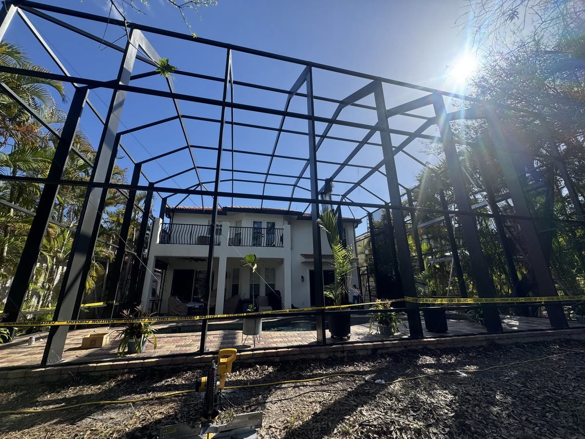 A two-storey pool cage frame with its screens off, ready for paint.