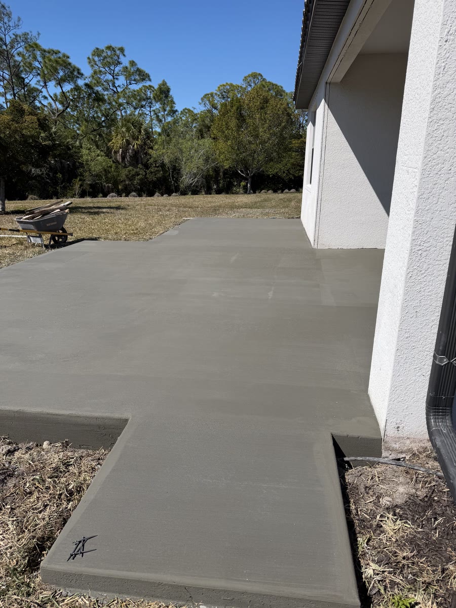 A fresh concrete slab and walk along the side of a house.